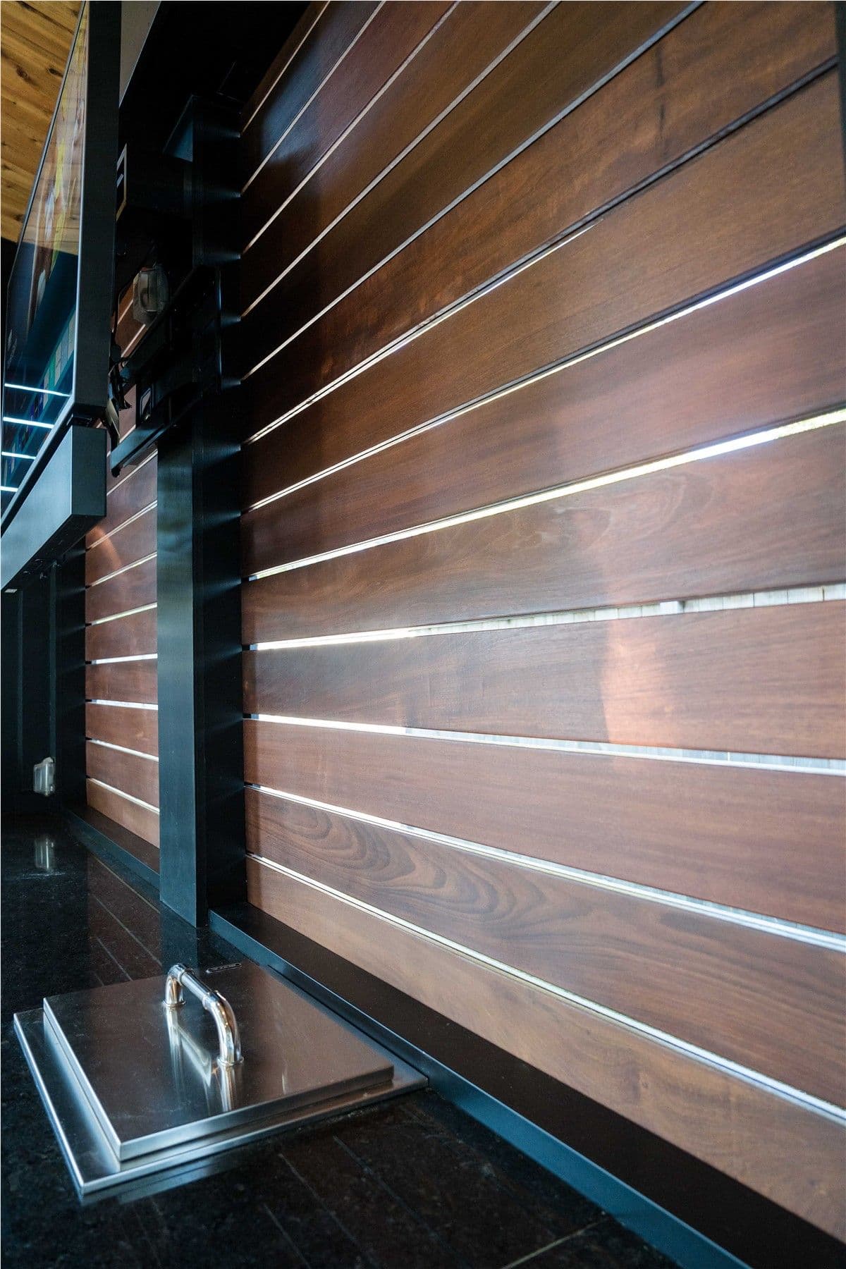 Close-up of dark wood panels of a privacy wall on a pergola.