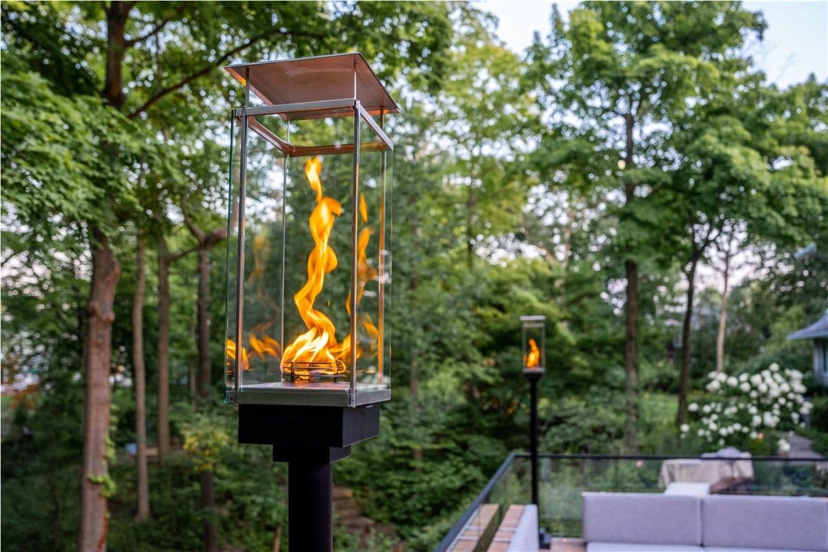 A torch stands on the rail of a back deck.